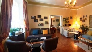 Una sala de estar con sofá, sillones, una mesa de centro y una zona de comedor con sillas y una mesa.