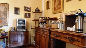 Una cocina con cafetera, frutero y radio antigua.