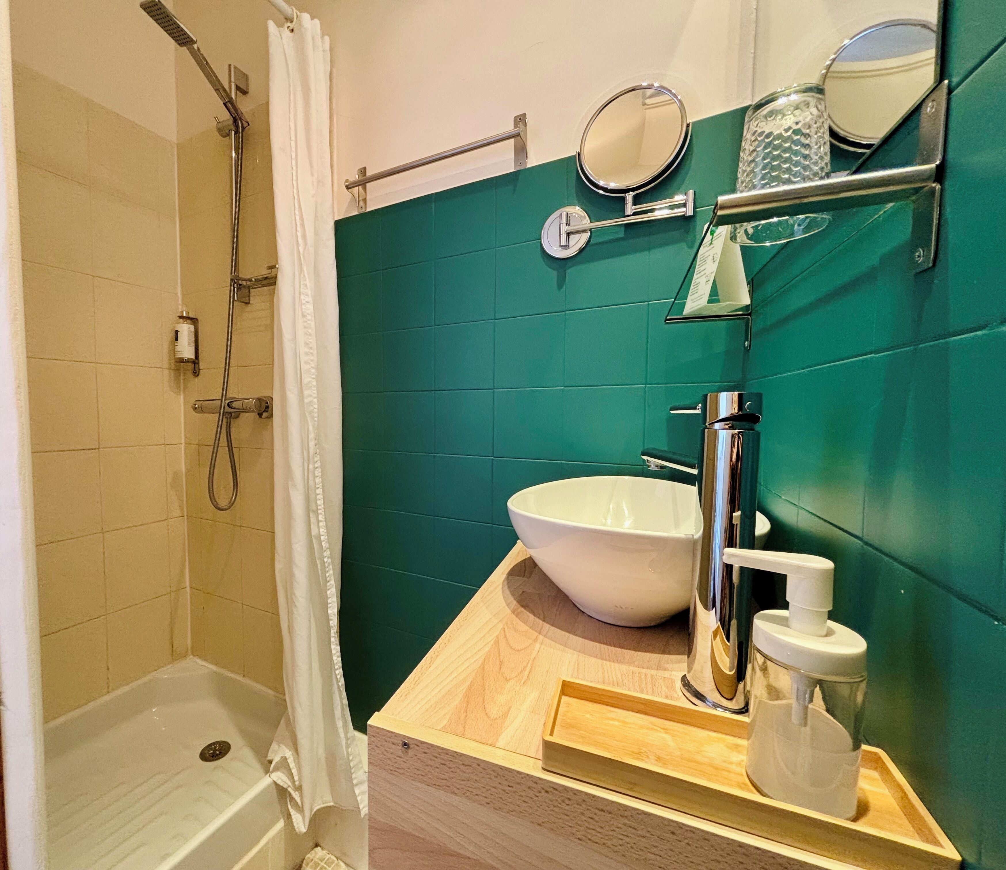 Ein Badezimmer mit Dusche, Waschbecken und Spiegel.