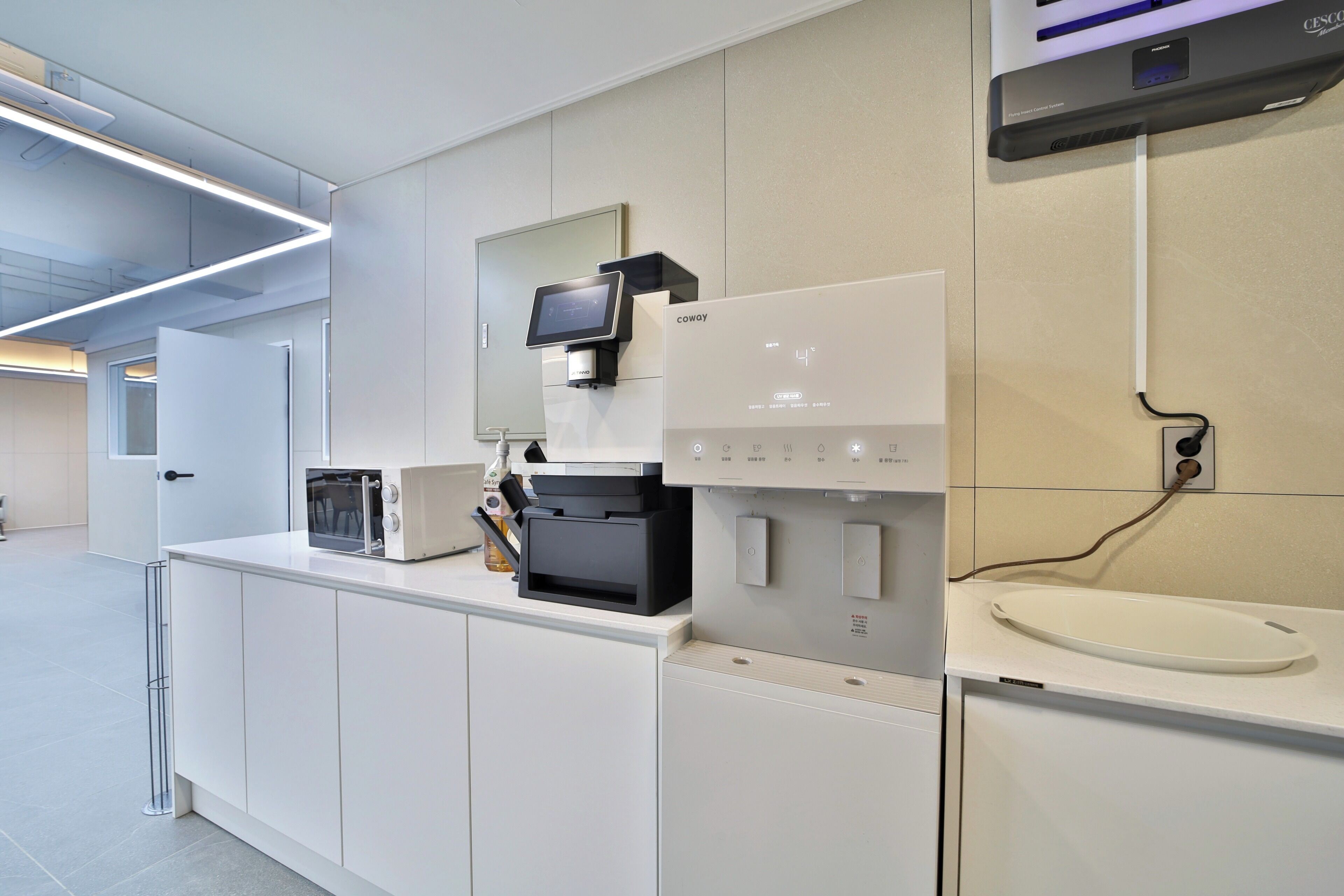 A modern kitchen with a coffee machine, microwave, and a sink.