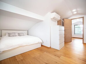 A bedroom with a bed, a wardrobe, and a window.