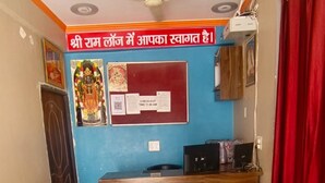 A reception area with a blue wall, a wooden reception desk, a ceiling fan, and a check-out sign.