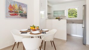 A modern kitchen with white cabinets, a built-in oven, and a window overlooking greenery. - Apartment Playa Dor 27 in first sea line, Cala Gran beach (Cala D'or (Santanyí))
