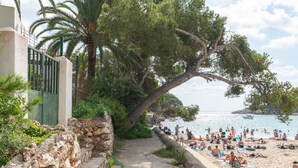 A coastal walkway leading to a beach with people sunbathing and swimming. - Apartment Playa Dor 27 in first sea line, Cala Gran beach (Cala D'or (Santanyí))