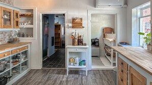 A kitchen with wooden cabinets, a central island, and a view of the adjacent dining area. - Cozy home in Føvling with WiFi (Føvling)
