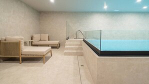 Une salle de spa équipée d’une baignoire, de deux fauteuils et d’une petite table.