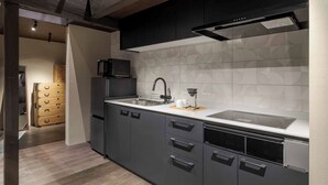 Una cocina moderna con armarios oscuros, un lavamanos de acero inoxidable y un microondas.
