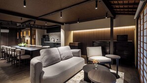 Un intérieur moderne comprenant un canapé, des fauteuils, une table à manger et un coin cuisine.