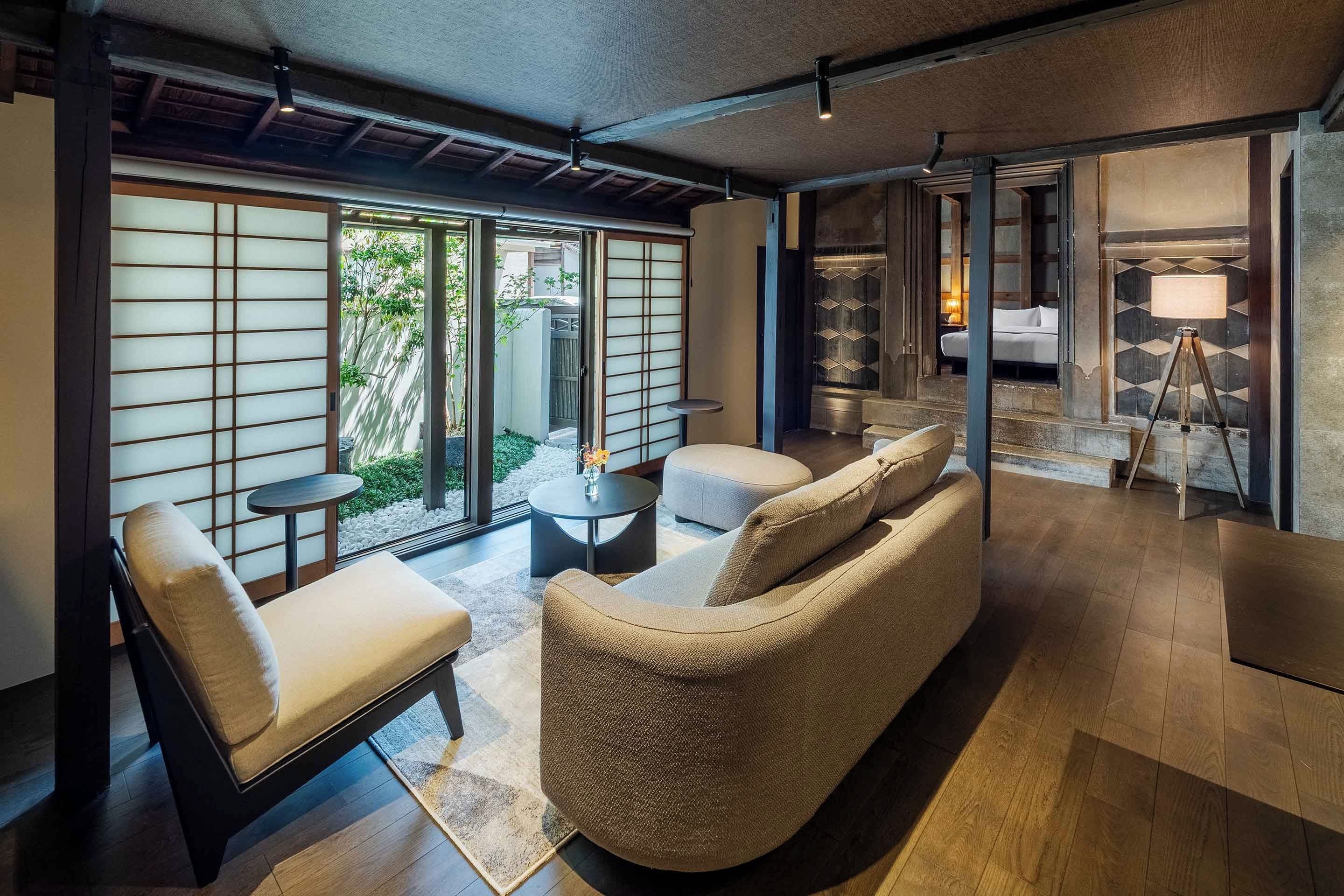 A modern interior with a sofa, chairs, a small table, and a lamp.