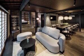 Un intérieur moderne avec un canapé, des tables rondes et un coin repas avec des chaises.