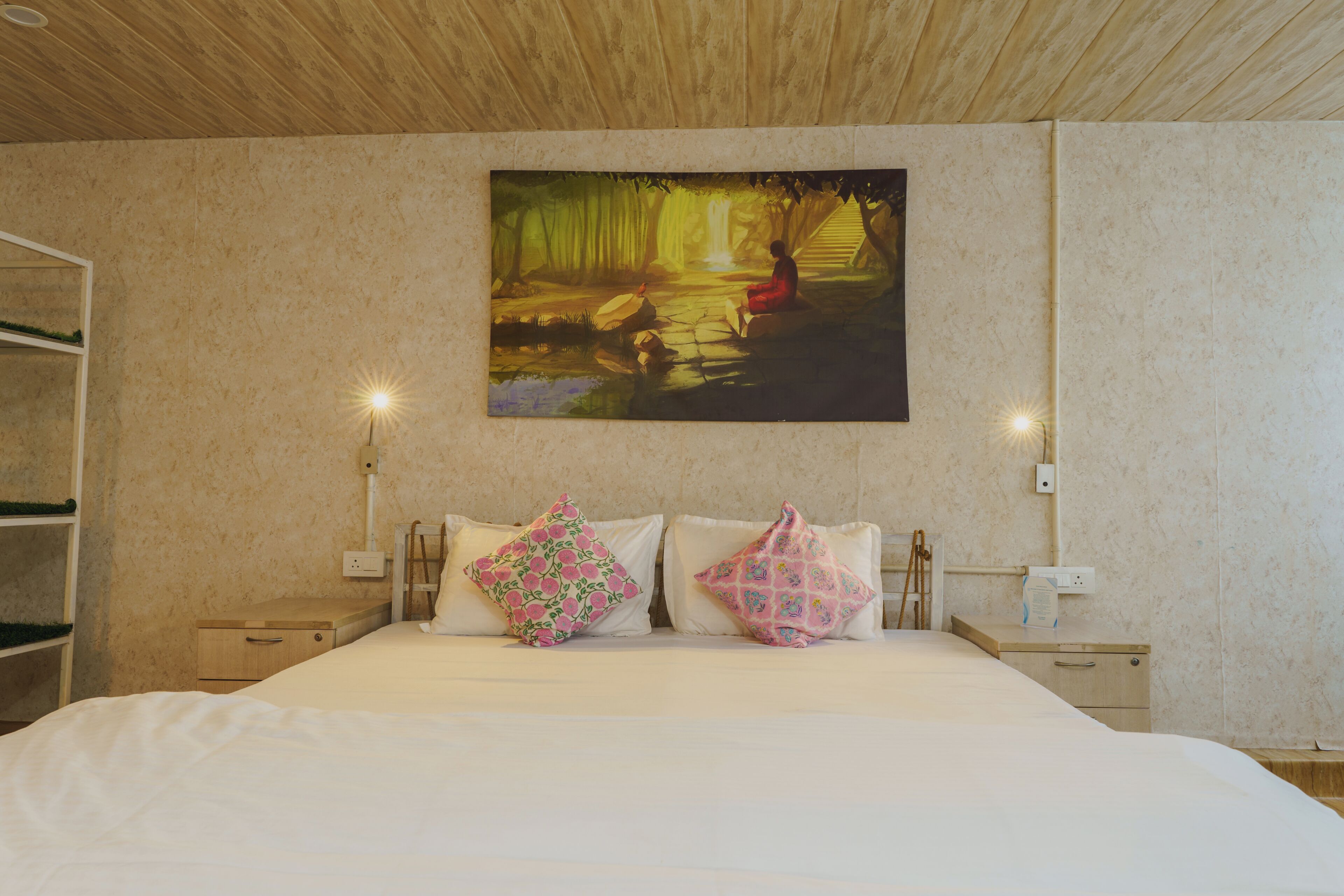 Ein Schlafzimmer mit einem Bett, zwei Nachttischen, einem Wandbild und einer Holzbalkendecke.