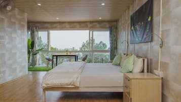 Un dormitorio con cama, mesita de noche y vistas al exterior.
