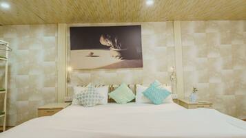 A bedroom with a bed, a nightstand, a wall-mounted picture, and a wooden ceiling.