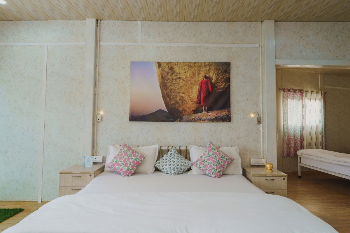 Un dormitorio con una cama grande, mesitas de noche y un cuadro colgado en la pared.