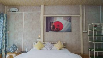 Un dormitorio con una cama, almohadas, una silla, un estante y un aire acondicionado de pared.