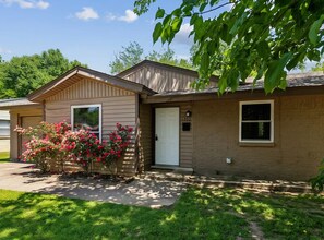 A two-story residential building with a front door, a mailbox, and a number '1202' on the wall. - Peaceful 4-bdrm HomeAway Texas Rose Euless with covered patio and fenced yard. (Euless)