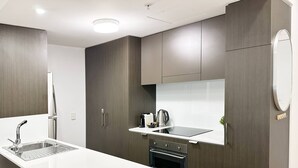 Una cucina moderna con isola centrale, forno integrato e lavello in acciaio inossidabile.