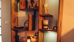 A wooden shelving unit with various decorative items and a framed picture. - Lights & Kulture Homes a 2-bedroom apartment for creatives in Arusha Region (Arusha Region)