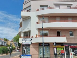 A multi-story building with balconies, a sign indicating 'Lannion Treguier' and 'Le Port,' and a storefront with various signs. - Hotel de Ville by Interhome (Perros Guirec)