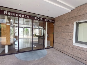 Entrada de hotel con un cartel que dice 'Résidence Hôtel deVille'.