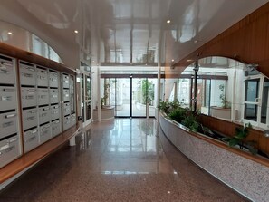 A modern lobby with a polished floor, metal lockers, and a reception desk. - Hotel de Ville by Interhome (Perros Guirec)