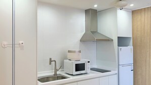 Una cocina moderna con un lavamanos de acero inoxidable, un microondas y un horno empotrado.