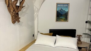 Un dormitorio con una cama grande, decoración de pared de madera, un cuadro enmarcado y una mesita de noche.