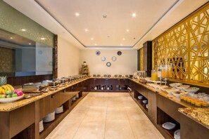 Montaje de bufé con diversas opciones de comida y una pared decorativa.