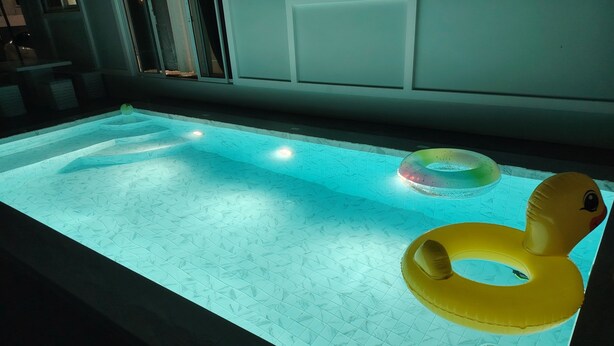 A swimming pool with a textured floor, a yellow inflatable ring, and a circular float. - ROW HOUSE WITH PRIVATE POOL, Corner Townhouse with Private Pool (หัวหิน)