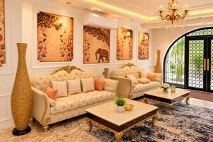 A luxurious living room with two sofas, a coffee table, and a large vase.