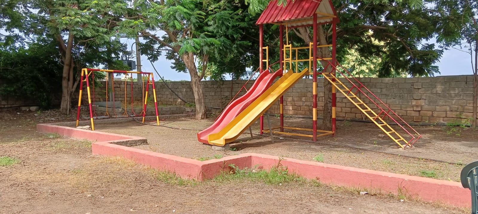 A playground with a slide and swings.