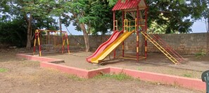 Un parque infantil con tobogán y columpios.