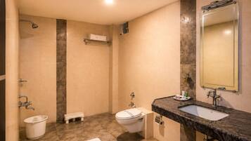 Un baño con bañera, inodoro, lavabo y espejo.