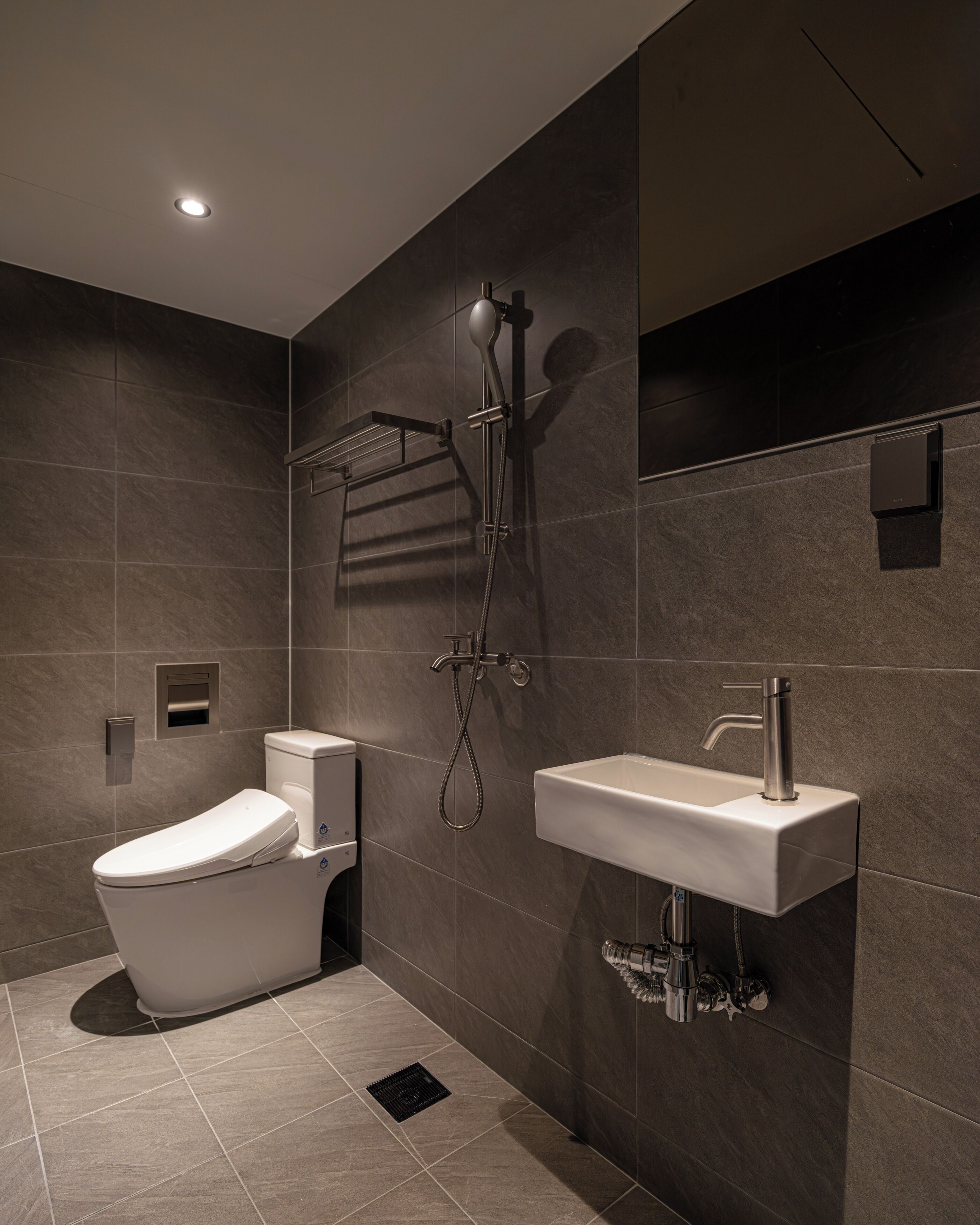 Un baño moderno con inodoro, ducha y lavamanos.