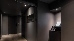 Um elevador moderno com porta de vidro, painel de controle e piso de madeira.