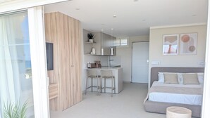 Ein modernes Apartment mit Küche, Essbereich und Schlafzimmer.