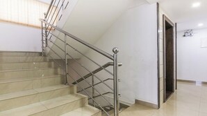 Escada com corrimãos de metal e degraus bege.