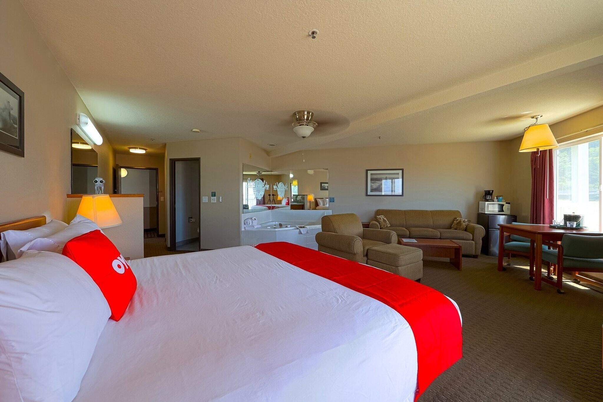 Ein Hotelzimmer mit einem großen Bett, einer Schlafcouch, einem Schreibtisch und einer Küchenzeile.