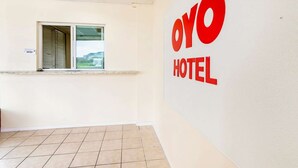 A reception area with a window, a counter, and a wall with 'OYO HOTEL' signage. - 2 King Bed Non Smoking | Antonio Lackland (San-Antonio)