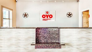 A reception area with a 'OYO HOTEL' sign, a star decoration, and a patterned wall.