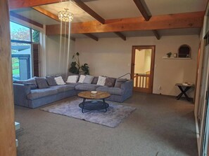 Ein Wohnzimmer mit einem Ecksofa, einem runden Couchtisch und einem Deckenventilator.