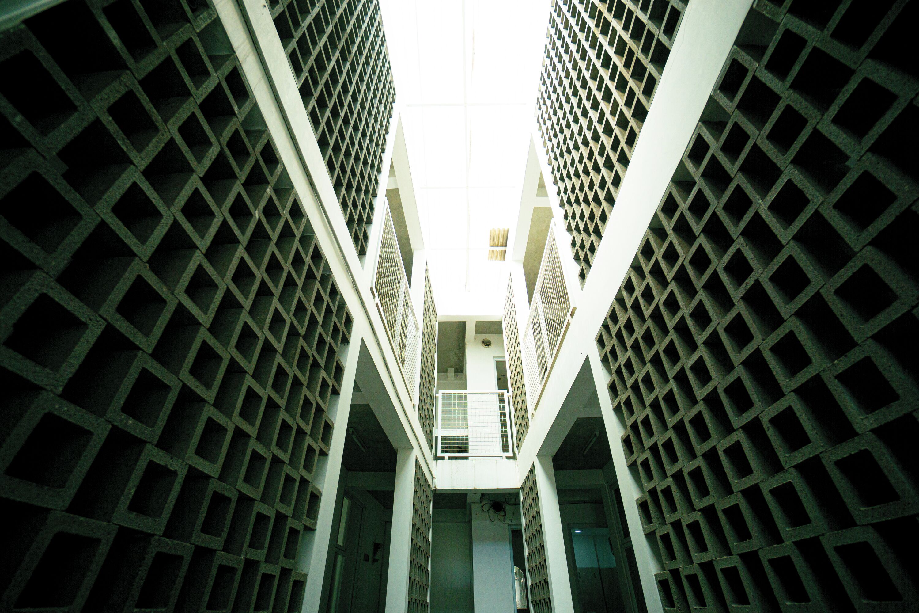A high-rise building with a grid-like facade and a central open space.