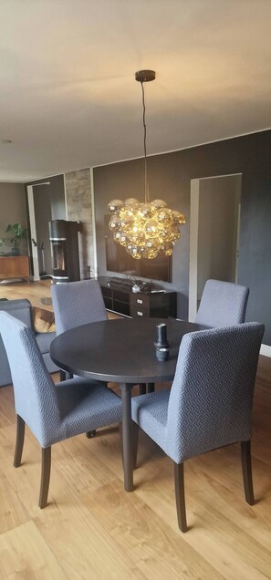 A modern dining area with a round table, grey upholstered chairs, and a unique spherical chandelier. - Charming house, 8 beds, possibility to rent a boat (Bjørnafjorden)