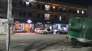 Ein mehrstöckiges Gebäude mit Restaurant im Erdgeschoss und einem Parkplatz.