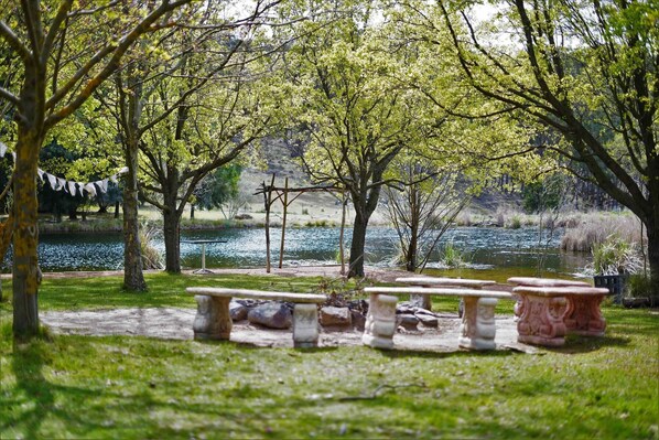 A serene outdoor seating area with stone benches and a pond.