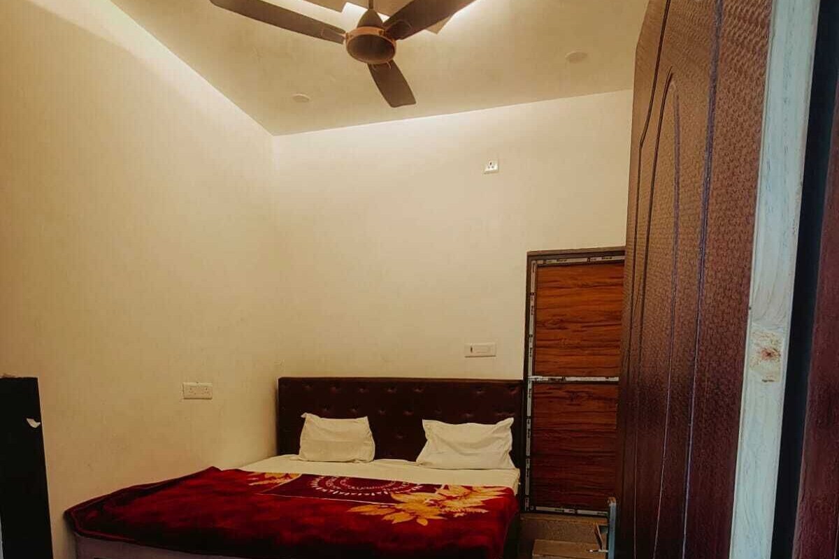 Un dormitorio con cama, ventilador de techo y armario de madera.