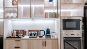 A modern kitchen with built-in appliances, including a coffee maker, toaster, and kettle.
