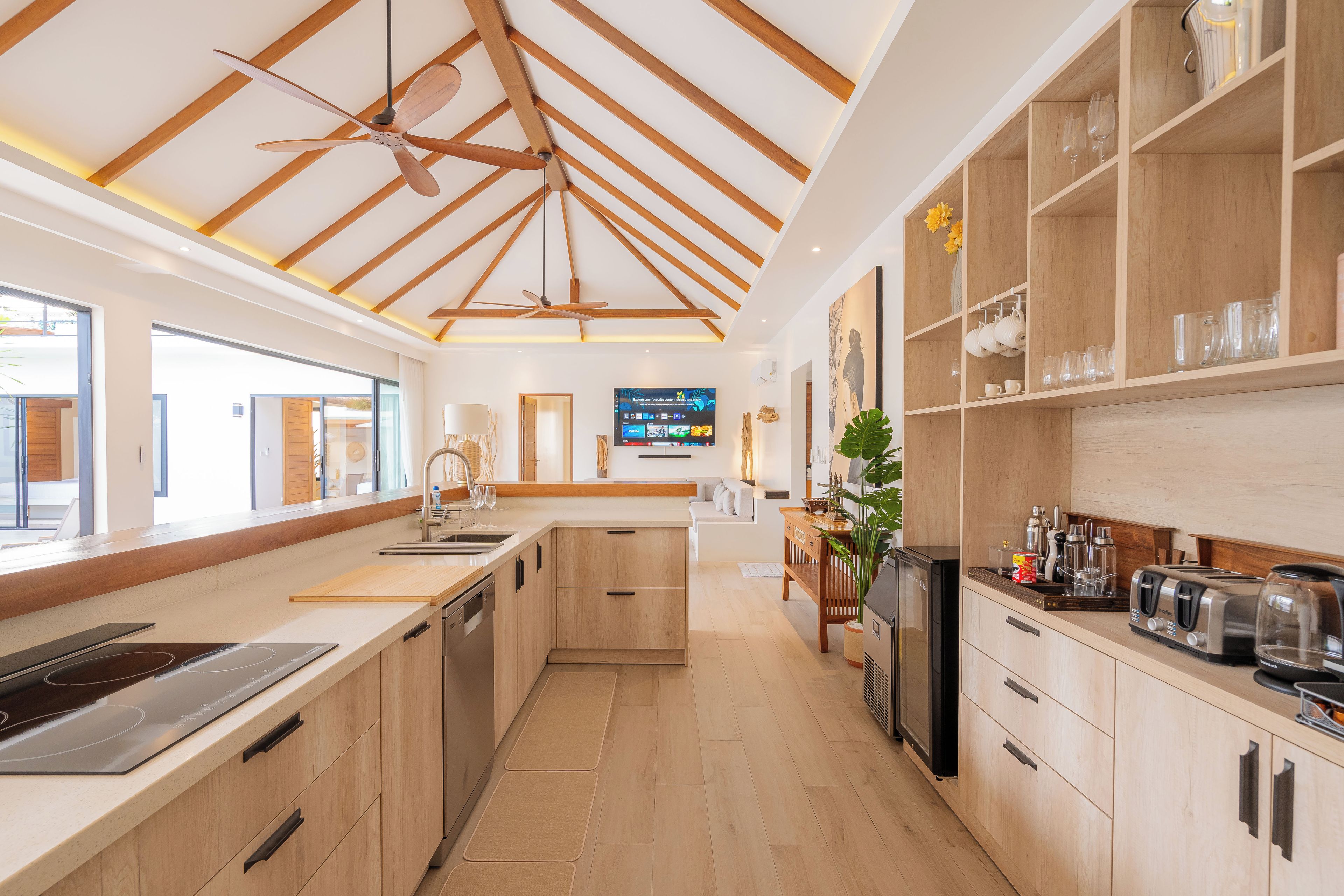 Eine moderne Küche mit Holzschränken, einem Backofen und einer großen Kochinsel mit Spüle.