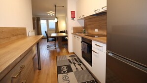 A modern kitchen with a wooden countertop, built-in oven, and a stainless steel refrigerator. - Apartment in Strengen with mountain views (Strengen)