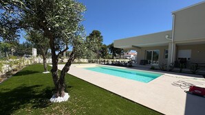 A modern pool area with a clear blue pool, surrounded by a well-maintained lawn and a tree. - Villa in Augusta with 3 bedrooms sleeps 8 (Augusta)